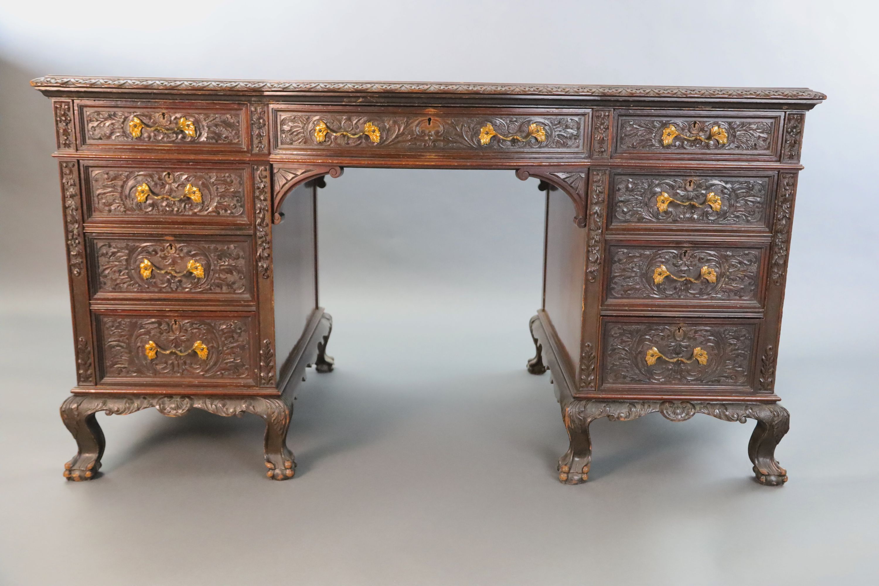 An Edwardian foliate carved mahogany serpentine kneehole desk, W.4ft 6in. D.2ft 5in. H.2ft 6in.